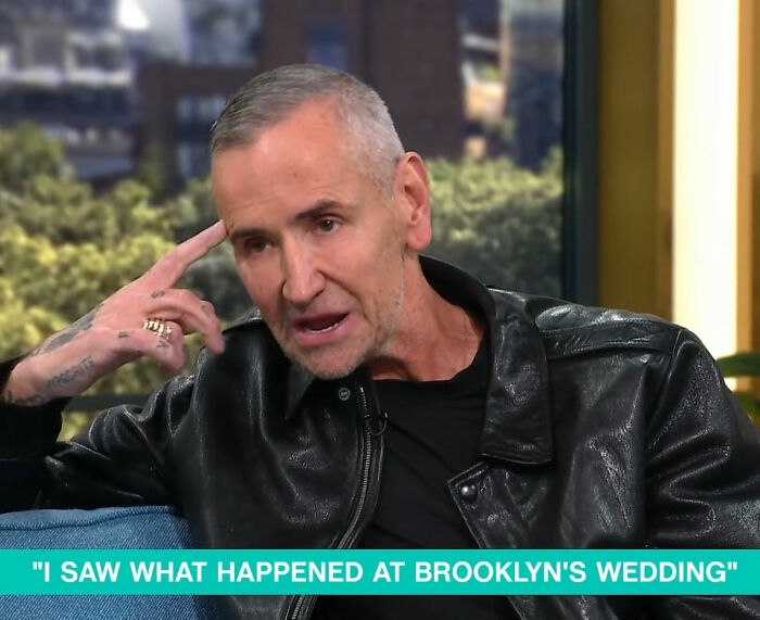 DJ at Brooklyn Beckham's wedding speaking during an interview, wearing a black leather jacket and discussing dance accusations.