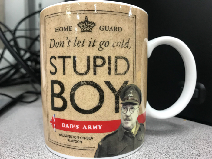Coffee mug on desk with vintage Dad’s Army design and text, suitable for people who hate New Year’s resolutions.