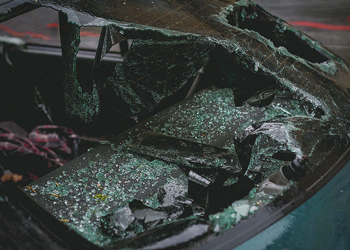 Shattered car windshield with broken glass scattered, symbolizing worst things medical professionals have said to patients.
