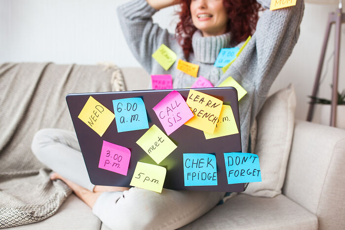 Woman surrounded by colorful sticky notes on laptop and clothing, reflecting moments that hit people harder than expected