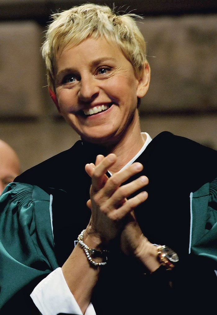 Smiling woman with short blonde hair applauding, representing celebrities whose careers crashed and never recovered.