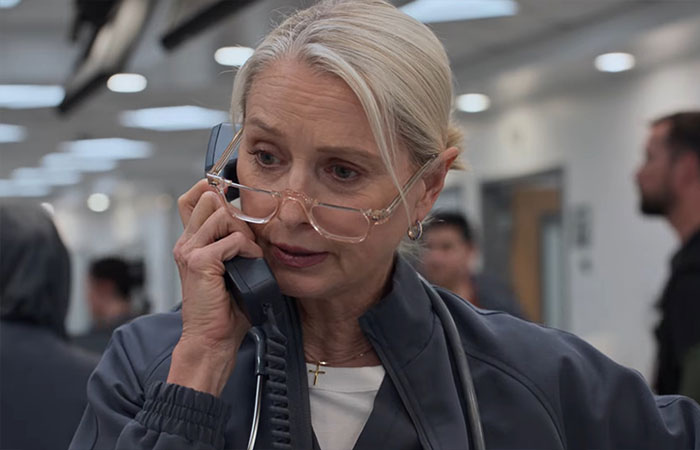 Middle-aged woman with glasses talking on the phone in a hospital setting referencing 2901 meaning Pitt Season 2 ending