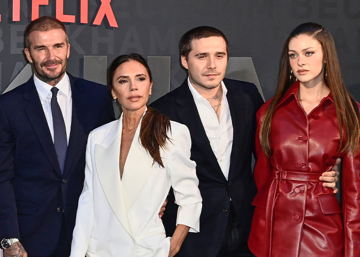 David Beckham, Victoria Beckham, Brooklyn Beckham, and Nicola Peltz posing together at an event, linked to Beckham family photo clip.