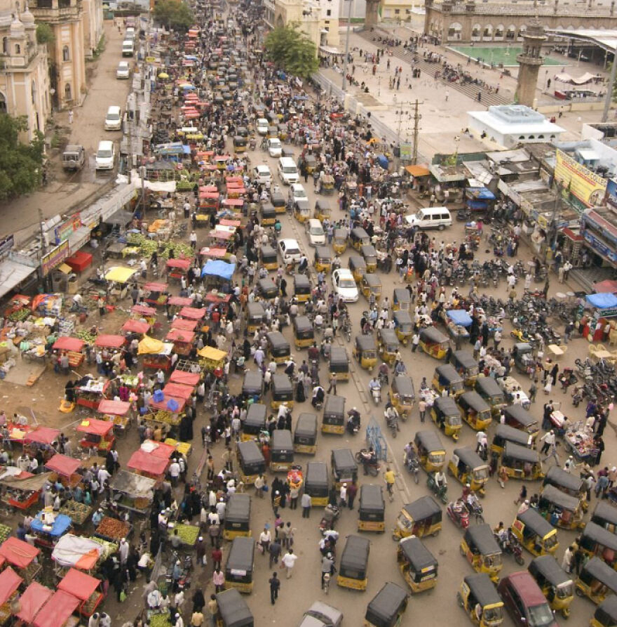 Crowded city street showing heavy traffic and numerous pedestrians in one of the cities with worst traffic in the world.