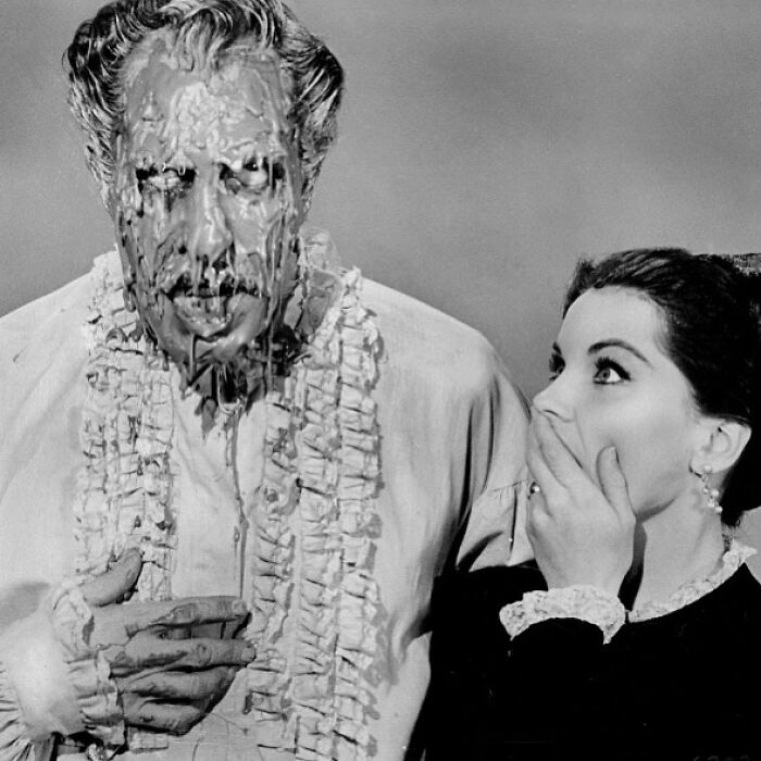 Old black and white creepy photo of a man covered in slime and a shocked woman looking at him in horror.