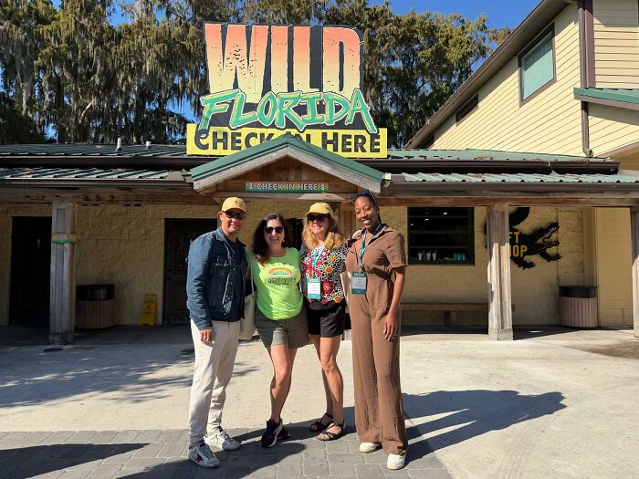 Group of visitors posing outside Wild Florida attraction, showcasing the beauty and calm of Central Florida experiences.