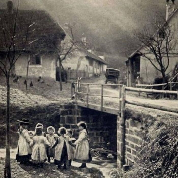 Group of children playing near a rural bridge in a historic village, illustrating the sad and beautiful history of humanity.