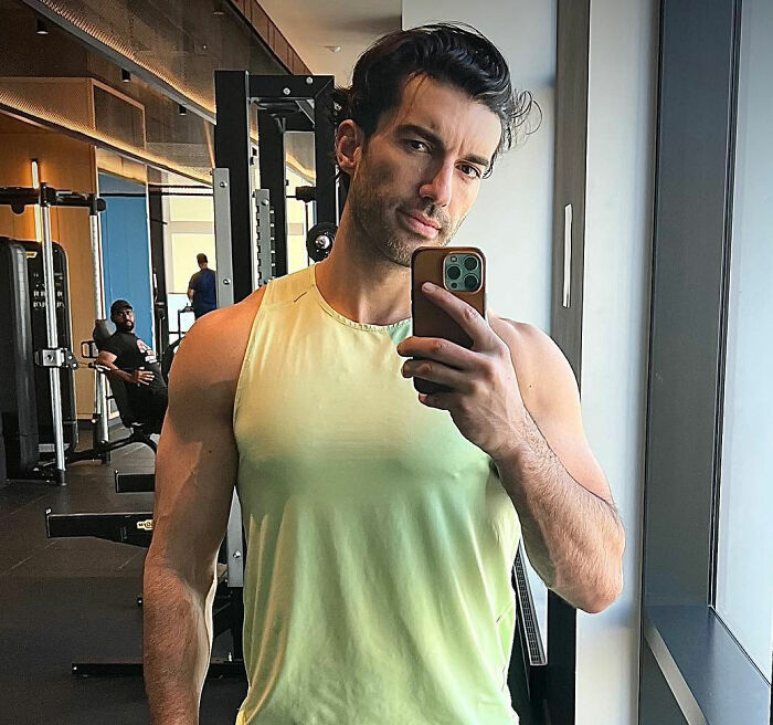 Man in gym taking selfie in mirror, wearing yellow sleeveless shirt, highlighting Kim Kardashian Taylor Swift comments suspicion. Man in gym taking selfie in mirror, wearing yellow sleeveless shirt, highlighting Kim Kardashian Taylor Swift comments suspicion.