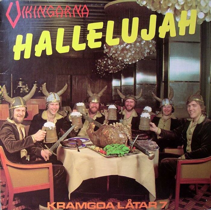 Group of men wearing Viking helmets, holding beer mugs and swords around a table in a hilariously bad album cover.