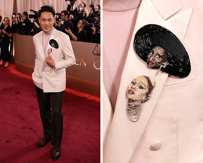 Man on red carpet wearing light pink blazer with beaded face brooches at 2026 Golden Globes red carpet fashion disasters event