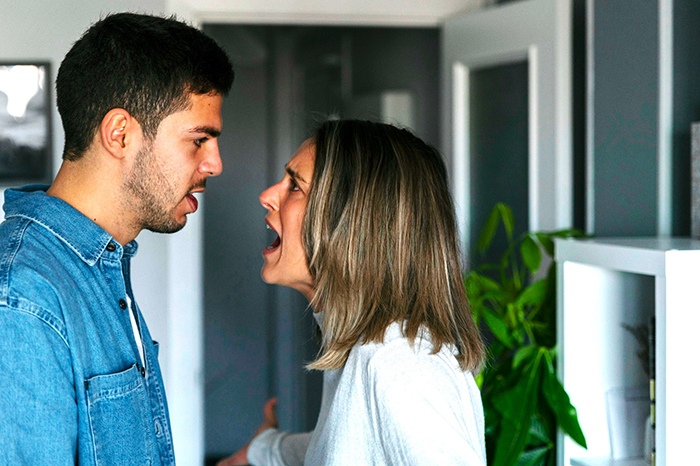 Young man and woman arguing at home, highlighting relationship conflict and challenges of moving in without learning chores.