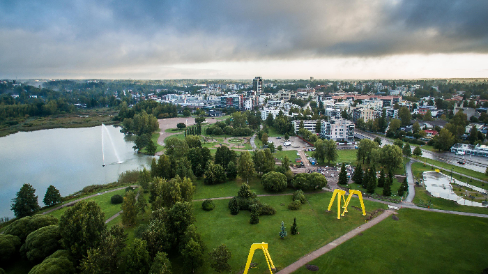 A peaceful park with playground swings and a lake in one of the best countries to raise a family.