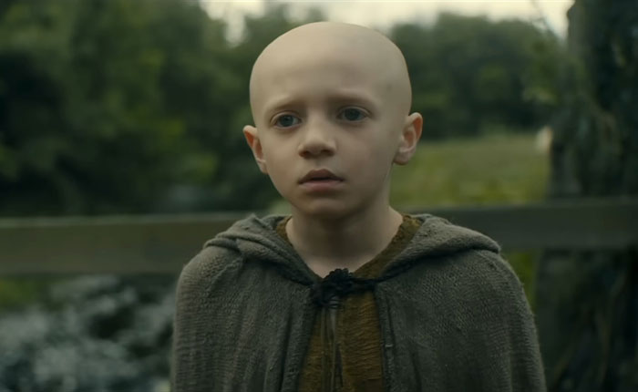 Young character in a cloak from A Knight Of The Seven Kingdoms series amid fans divided over Rotten Tomatoes rating.