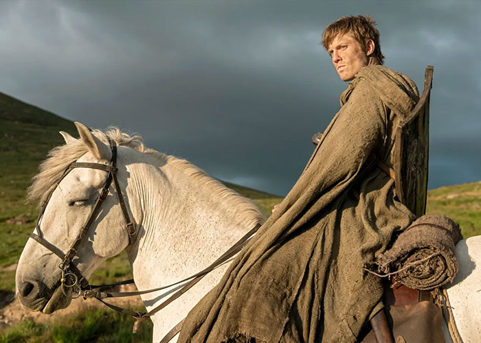 Actor in medieval costume on horseback in a dramatic outdoor scene from A Knight of the Seven Kingdoms ahead of release.