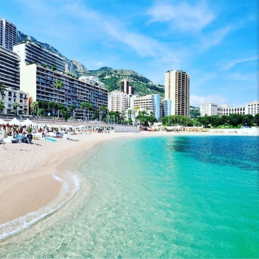 Beachfront cityscape with clear turquoise water and high-rise buildings, representing global standard for paid leave.