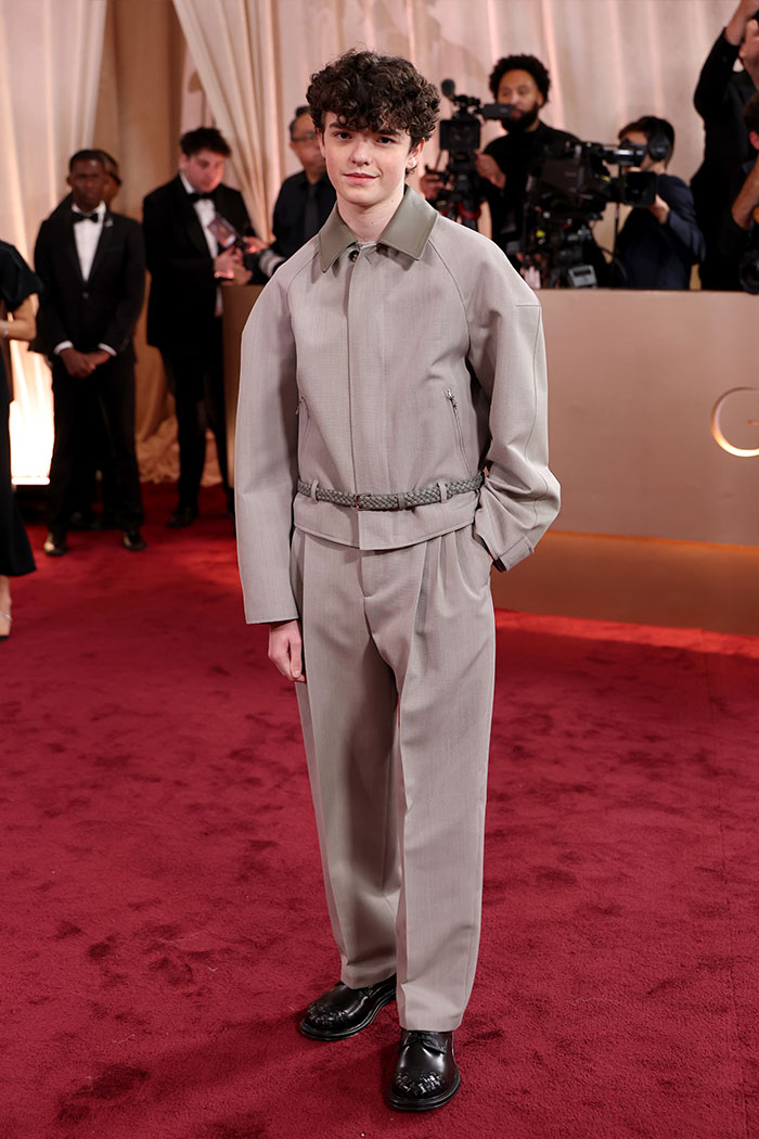 Young man on the red carpet wearing an oversized gray suit, part of 2026 Golden Globes red carpet fashion disasters.