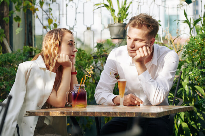 A couple sitting at an outdoor table, engaged in conversation about some of the fastest times couples said I do.