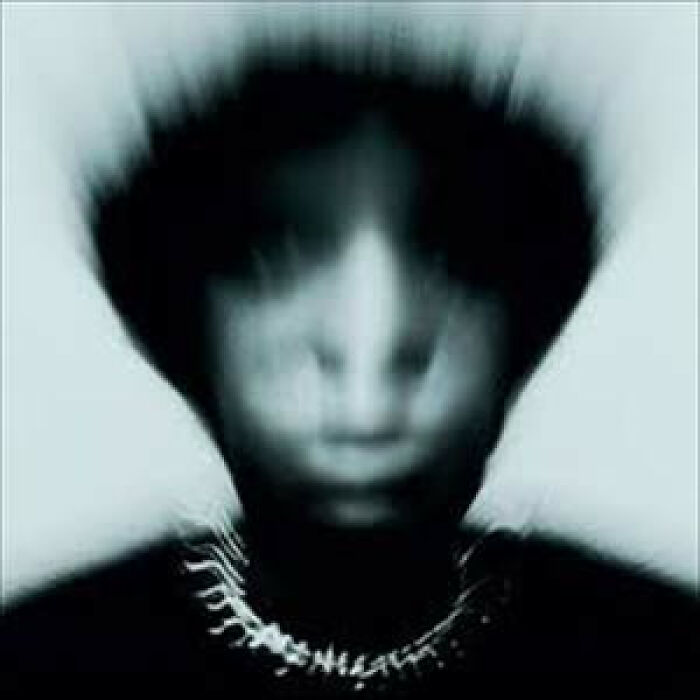 Blurry black and white portrait on a hilariously bad album cover with distorted facial features and dark background.