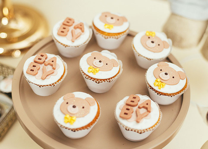 Cupcakes decorated with teddy bears and baby lettering, representing an inappropriate baby shower idea rejected by MIL.