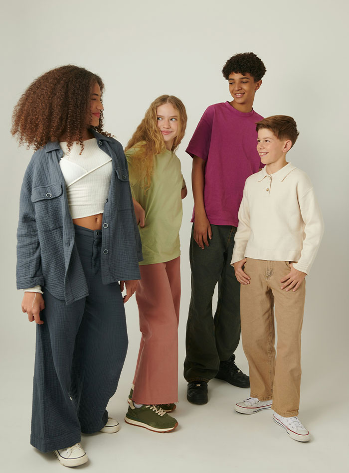 Four diverse teenagers smiling and chatting, illustrating overused slang words and phrases to be banished in 2026. Four diverse teenagers smiling and chatting, illustrating overused slang words and phrases to be banished in 2026.