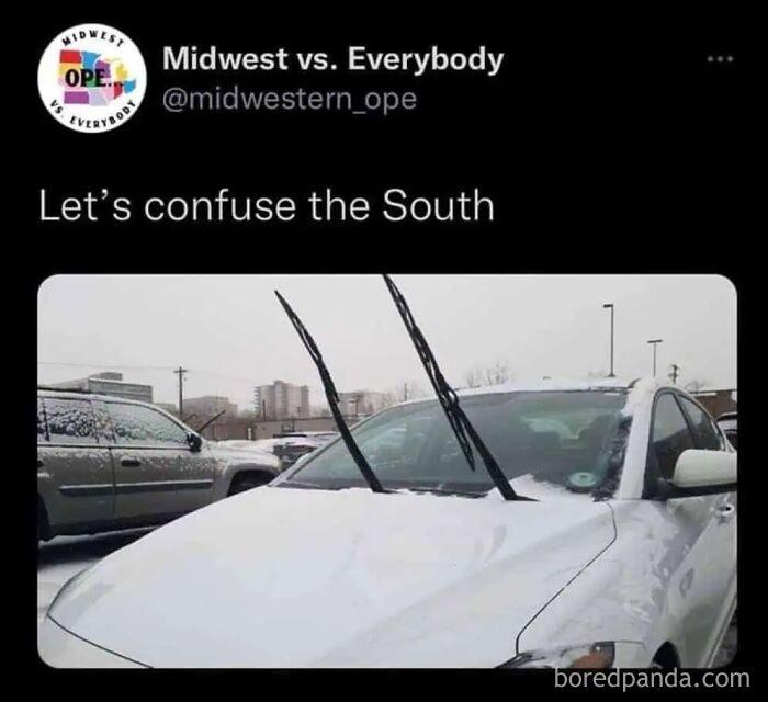 Car windshield with wipers raised in a snowy Midwest parking lot illustrating Midwest life memes.