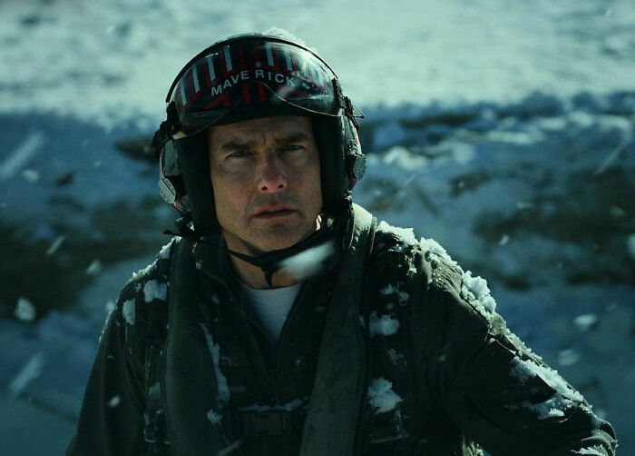 Actor in a pilot helmet on a snowy movie set, representing movie set workers sharing diva star experiences.