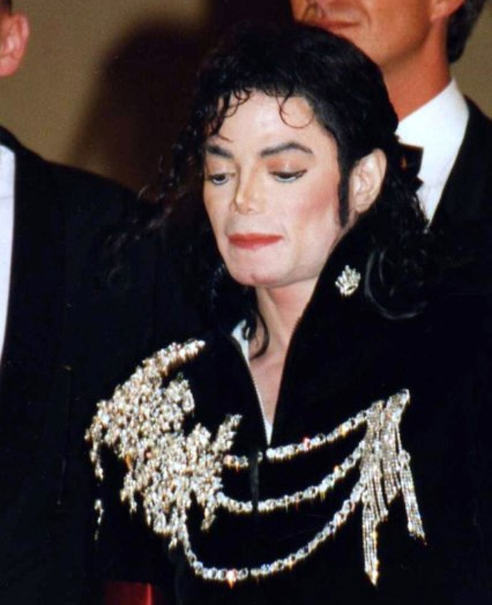 Michael Jackson in a black embellished jacket at an event, representing celebrities whose careers crashed and never recovered.