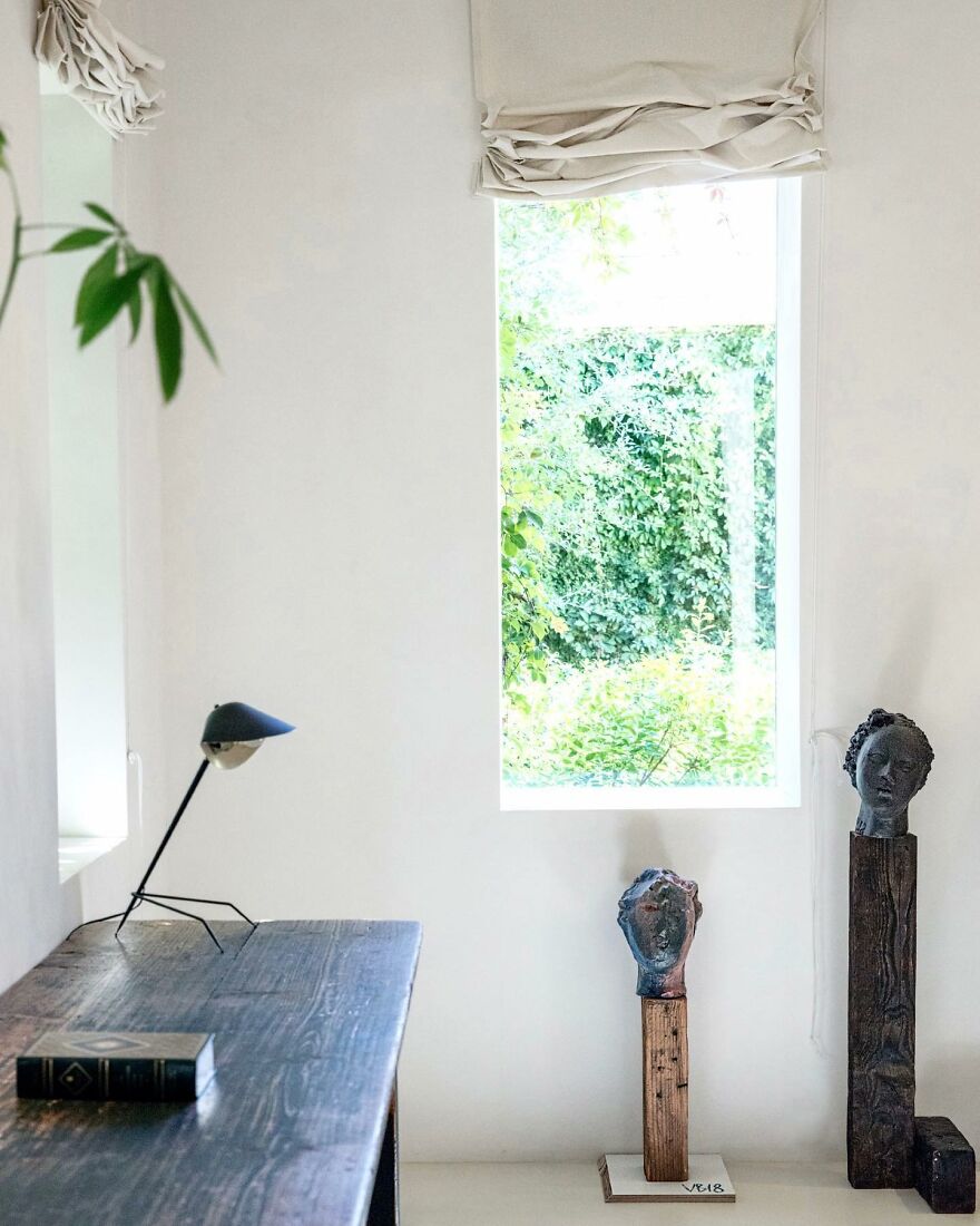 Minimalist interior with artistic sculptures and natural light, showcasing unique design in celebrity houses of the ultra-rich.