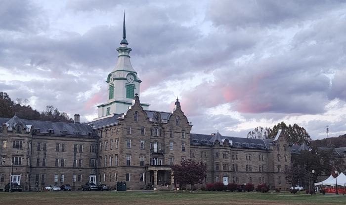 Historic eerie building under dark clouds, one of the most haunted places in America known for nightly screams and dark secrets.