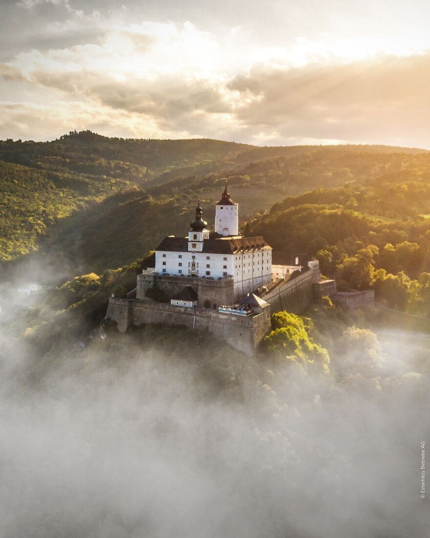 Castle on a hill surrounded by mist and forest, representing 15 nations setting new global standard for paid leave.