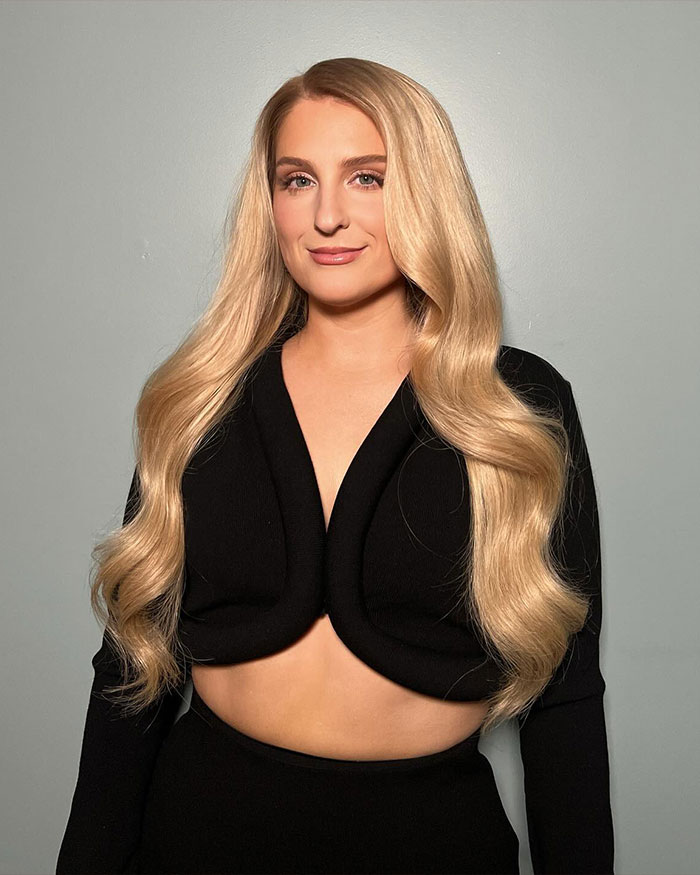 Meghan Trainor posing with long blonde hair and black outfit, addressing why she used a surrogate for her baby. Meghan Trainor posing with long blonde hair and black outfit, addressing why she used a surrogate for her baby.