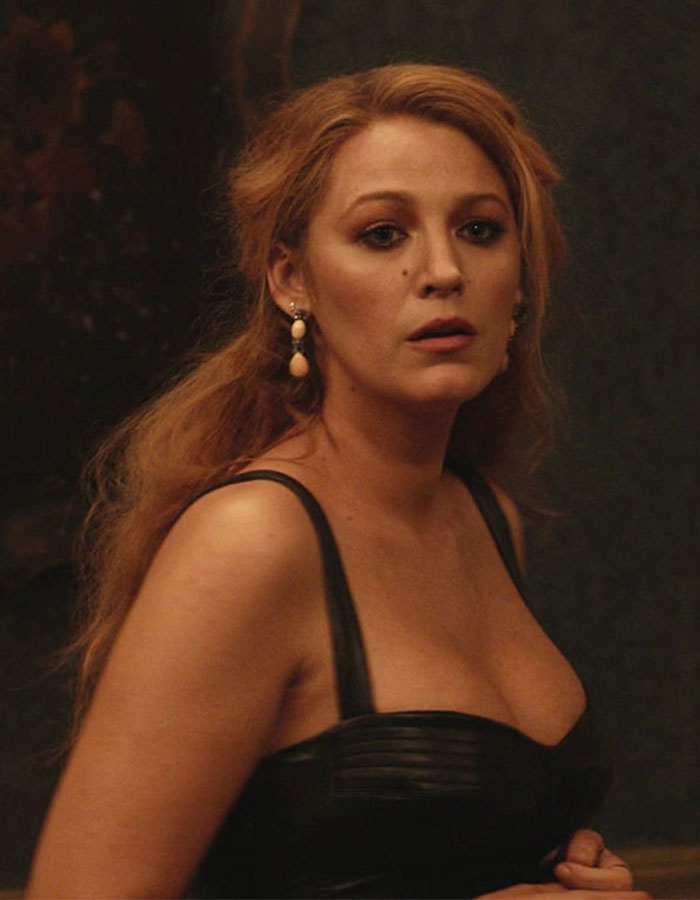 Blake Lively in a dark setting, wearing a black dress and earrings, related to disturbing comments by Justin Baldoni exposed.