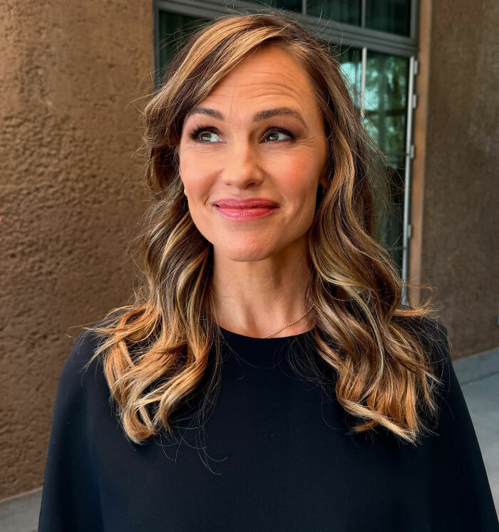 Jennifer Garner outdoors with highlighted hair, wearing a black top, reflecting on trauma bonded divorce with Ben Affleck.