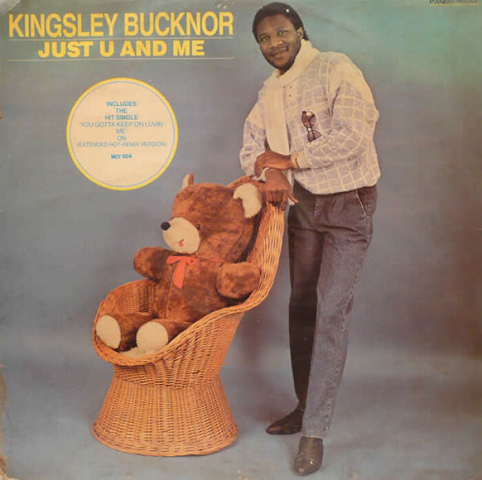 Kingsley Bucknor posing next to a large teddy bear in a wicker chair on a hilariously bad album cover.
