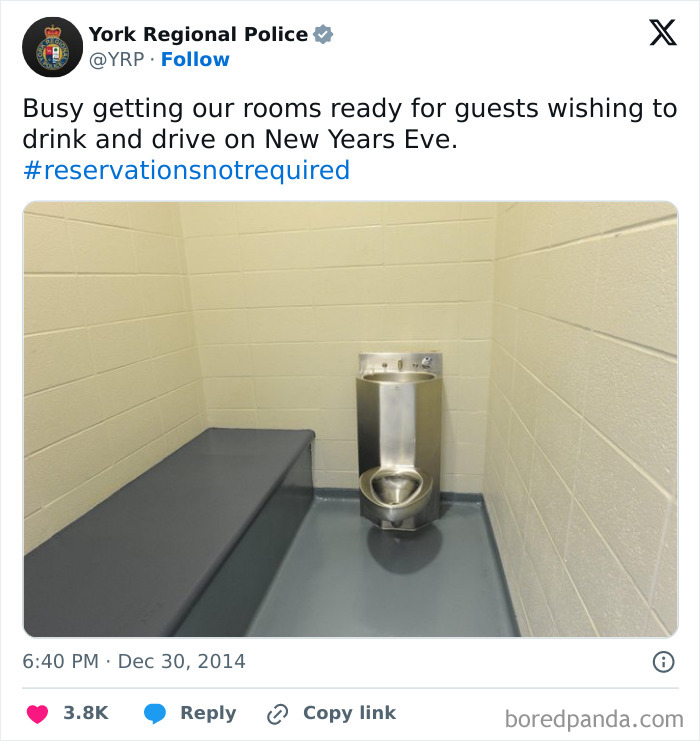 Minimal jail cell with metal toilet and bench posted on a police social media account showing unserious content.