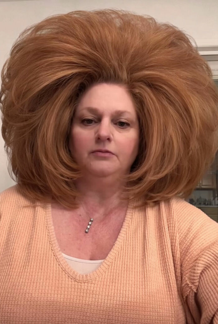 Middle-aged woman with voluminous hair wearing peach sweater during a cream cheese review sparking internet buzz. Middle-aged woman with voluminous hair wearing peach sweater during a cream cheese review sparking internet buzz.