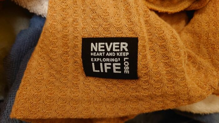 Close-up of a textured fabric label with unclear text, illustrating confusion and brain struggle to understand what they read.