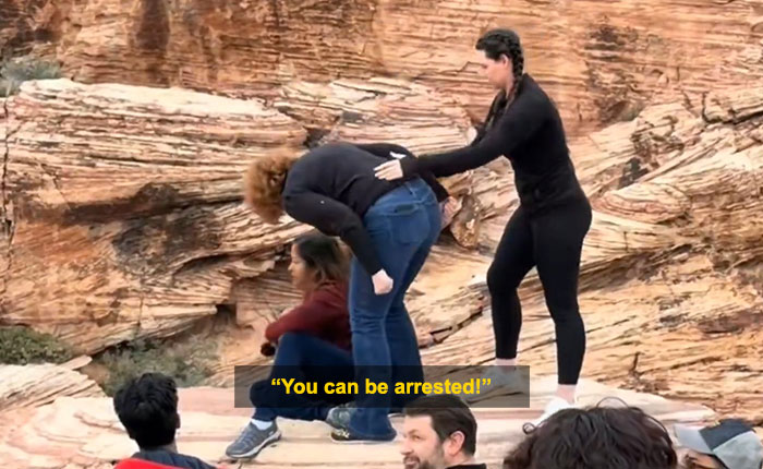 Woman blocking tourist&rsquo;s shot at Red Rock Canyon during viral first Karen of 2026 incident outdoors on rocky terrain.