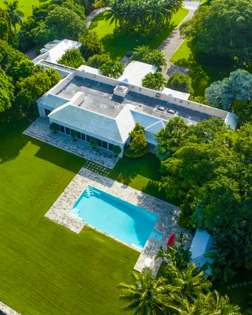 Aerial view of a luxurious celebrity house with a large pool, surrounded by lush greenery showcasing ultra-rich lifestyles.
