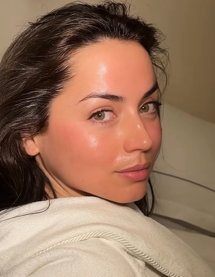 Woman with glowing skin lying back relaxed, showcasing celeb facialist secrets behind Golden Globes glow.