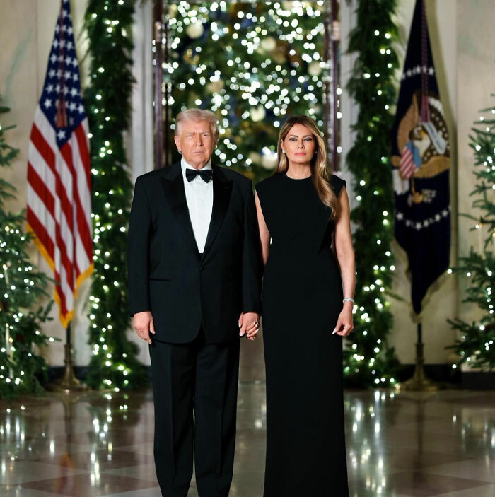 Melania Trump and Donald Trump dressed formally at Mar-a-Lago with festive holiday decorations in the background.