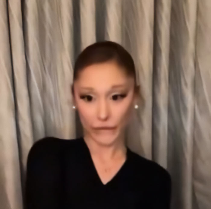 Ariana Grande with unusual facial expression and bizarre mannerisms in a recent interview setting.