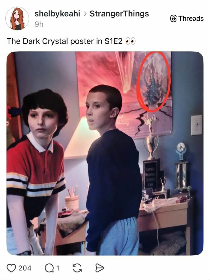 Two young characters from Stranger Things standing in a room with a Dark Crystal poster highlighted on the wall behind them.