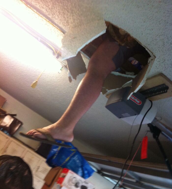 Sibling climbing through a broken ceiling, wearing flip-flops, showing that life is more fun with siblings in funny moments.