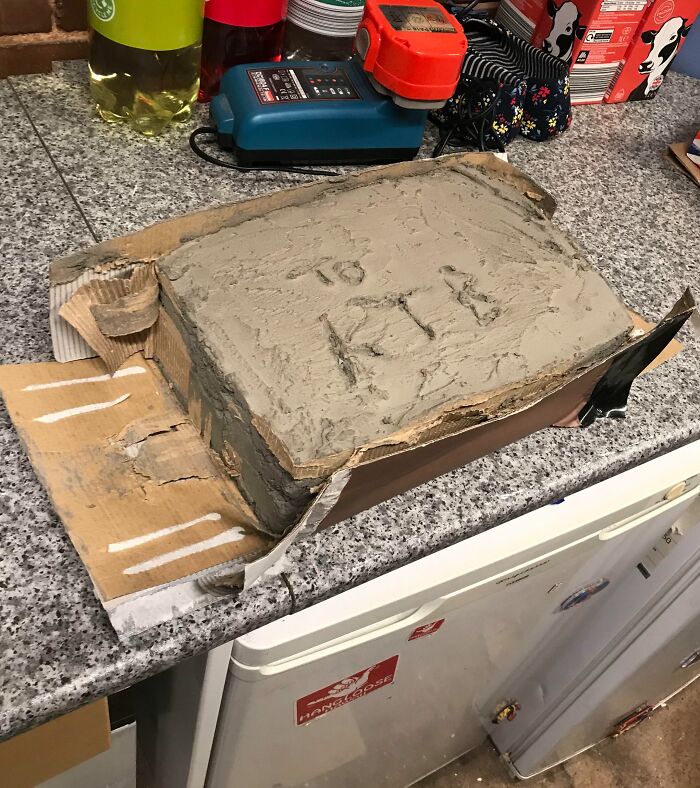 A homemade concrete cake on a kitchen counter, showing the fun creativity siblings bring to life.