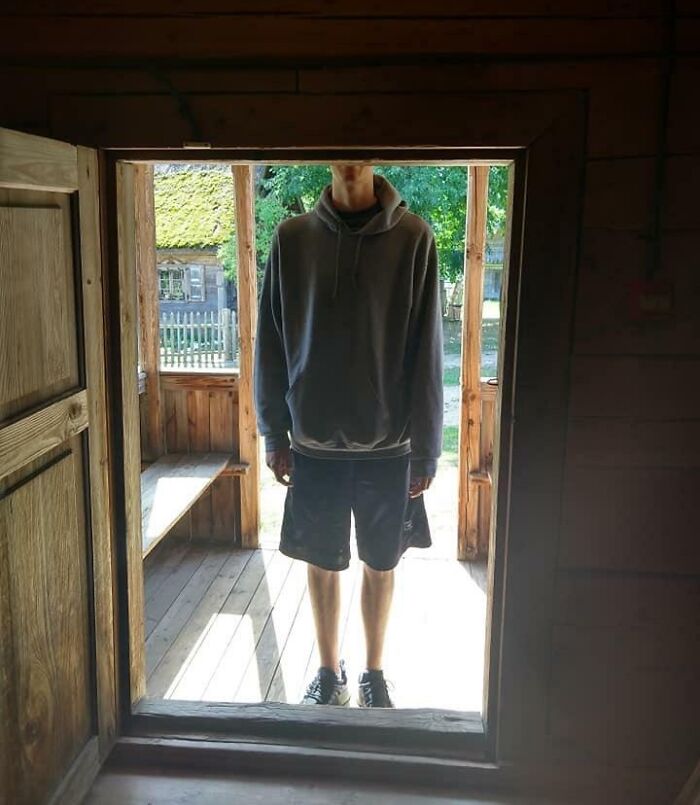 Person standing in a small doorway at a rustic wooden house, illustrating fun sibling moments and outdoor adventure.