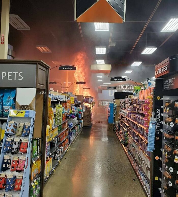 Smoke and flames erupting in grocery aisle with shoppers evacuated, example of next-level jerks
