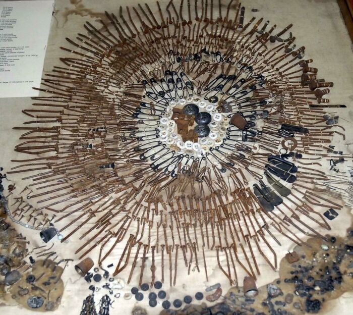 Disposición circular de objetos oxidados y botones creando una imagen inquietante que desafía la percepción de la realidad.