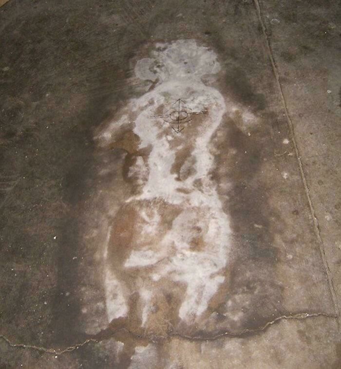 Faded, eerie figure resembling a ghostly outline on c*****d concrete, one of the scariest posts shared online.