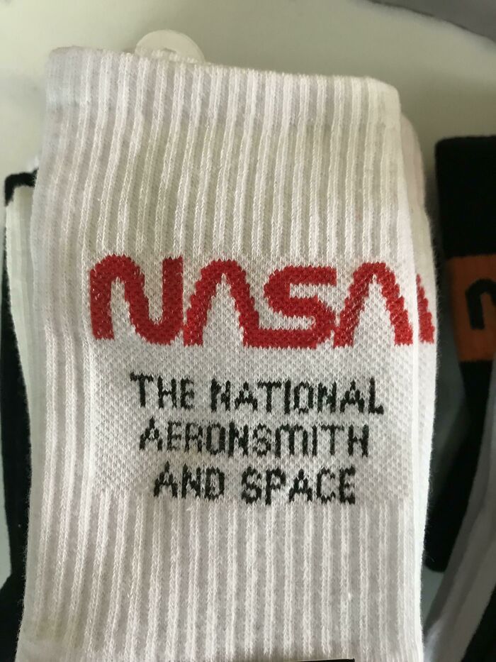 Pair of white socks with a misspelled NASA logo reading hilarious fashion fails as National Aerosmith and Space branding.